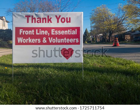 Thank you front line, essential workers & volunteers sign in front of a house during corona virus pandemic outbreak quarantine. Emergency workers, first responders, health care workers appreciation.