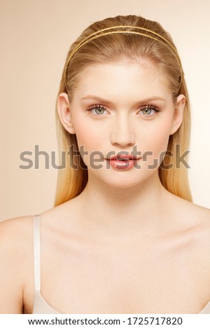 Portrait of young woman against orange background