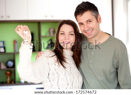 Image of happy young couple smiling and holding key ring