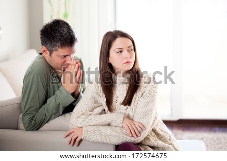 Image of young man begging his girlfriend to forgive him Royalty-Free Stock Photo #172574675