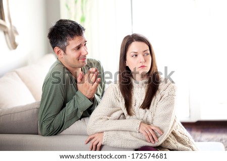 Image of young man begging his girlfriend to forgive him Royalty-Free Stock Photo #172574681