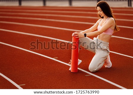 Young beautiful woman doing exercises outdoor, training process.