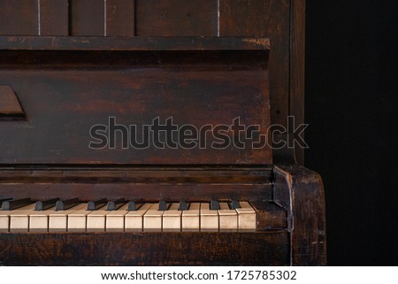 A part of old wooden piano keys on wooden musical instrument in front view on black background