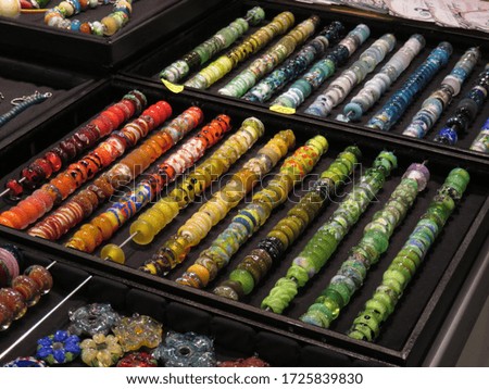 Multi-colored rainbow rows of glass beads in a tray