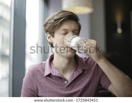 A shallow focus shot of a male drinking a coffee