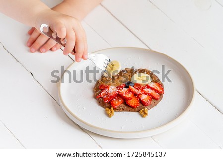 Creative pancake for kids in a plate isolated on white background.