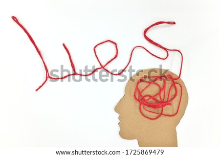 Lies, brainwashing and fake news concept. Human head profile silhouette with red yarn composed into word lies as brain gear. Royalty-Free Stock Photo #1725869479