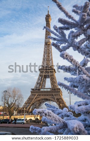Paris , France - December 15, 2019: Paris street with view on the famous paris eiffel tower on a cloudy rainy day. Royalty-Free Stock Photo #1725889033