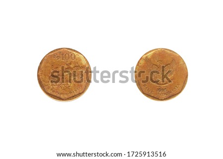 One hundred rupiah coins with symbol of Karapan Sapi from Indonesia isolated on white background.
