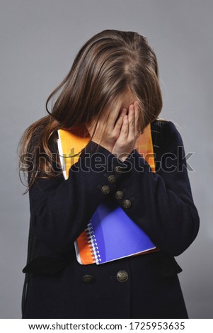 young lonely teenage student girl crying on studio isolated white background with school files and backpack 