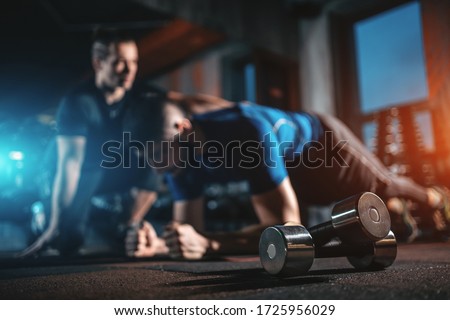 young man has workout with personal trainer in modern gym Royalty-Free Stock Photo #1725956029
