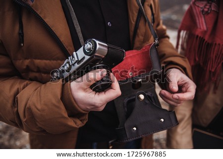 a man holds an old camera in his hand