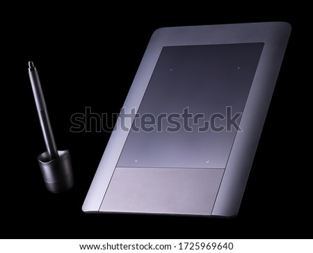 Top view of graphic tablet and pen for illustrators, designers and photographers isolated on black background