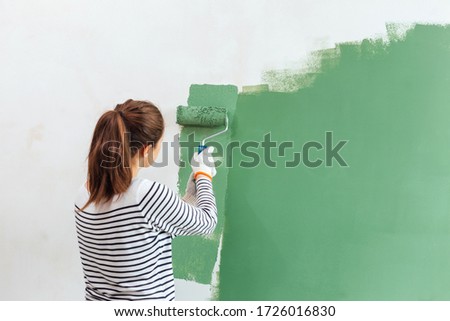 Young woman painting the wall Royalty-Free Stock Photo #1726016830