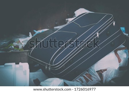 Travel suitcase for air travel in the trash in the trash among the garbage