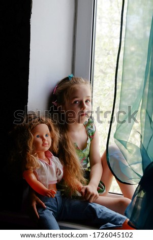 Little girl by the window. A 5 year old girl sits by the window at home. Childhood, child, window. Stay at home