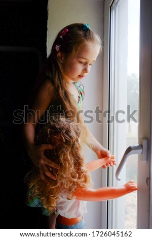 Little girl by the window. A 5 year old girl sits by the window at home. Childhood, child, window. Stay at home