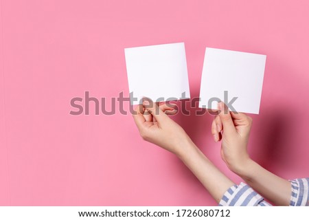 two photo frames on a pink background in the hands of a girl