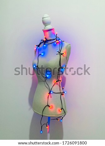 Mannequin dummy with lights of colorful garland, shopping holiday concept