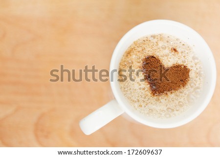 A cup of coffee with heart pattern 