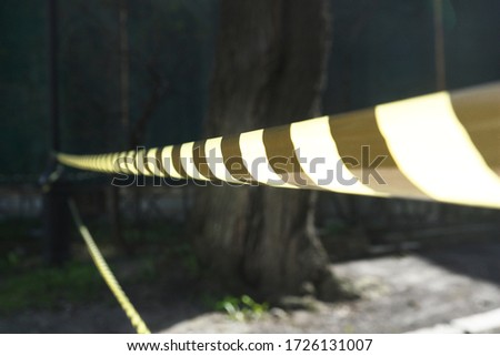 Photo of a background with a fencing striped yellow-black ribbon
