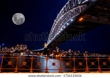 Sydney Harbour Bridge long night exposure showing the vibrant colours of the lights on the water And the glow of the full moon