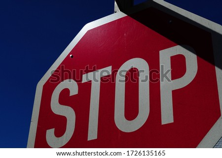 A closeup low angle shot of a red stop sign on blue sky background