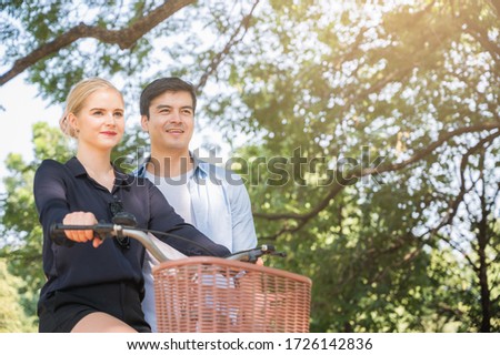 Young lovers are walking in the park Take the bike too On a nice, pleasant day