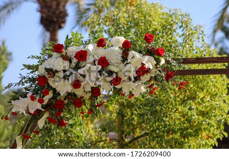 Large flower bouquet for outdoor wedding ceremony arch with red and white roses and hydrangeas, calla lilies mini carnations. 
