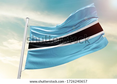 Botswana national flag cloth fabric waving on the sky  - Image