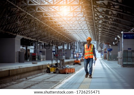 Portrait engineer under inspection and checking construction process railway and checking work on railroad station .Engineer wearing safety uniform and safety helmet in work. Royalty-Free Stock Photo #1726255471