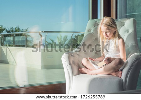 education and school concept - little student girl studying at school. Virtual class lesson on video during self isolation at home. Distant remote video education. Modern school study for kids.