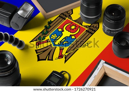 Moldova national flag with top view of personal photographer equipment and tools on white wooden table, copy space.