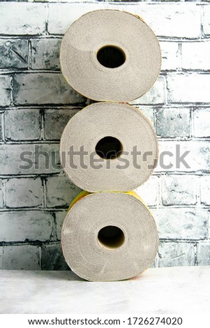 Rolls of toilet paper on table at the brick wall.