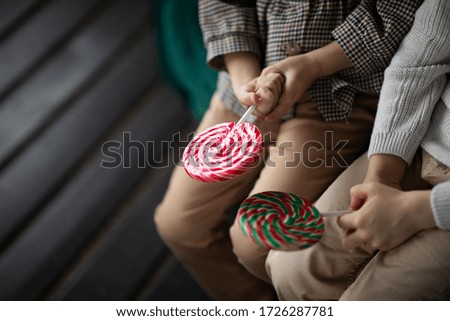Round lollipops in children's hands. Image with selective focus. Image with noise.