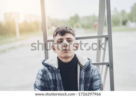Young man portrait outdoors, guy looks into distance thoughtfully