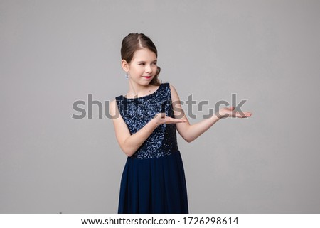Portrait of handsome young girl shows something new and recommends it, picture isolated on white background