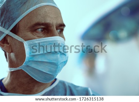 Male surgeon is wearing sterile mask while he is treating patients in hospital stock photo. Website banner
