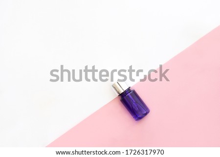 Blue dropper glass with moisturizing hyaluron serum on white and pink background with copy space. Beauty skincare, oraganic natural cosmetic, daily products. Stock photo.