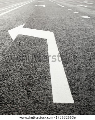 White turn left arrow on the road. Road marking. 