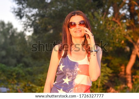Middle aged  woman speaking on phone outside . Beautiful woman speak on phone in sunset