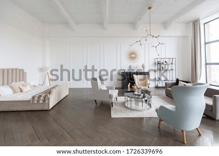 Modern luxury stylish apartment interior in pastel colors. a very bright room with huge windows filled with daylight. white walls, wooden parquet floors and a dark marble fireplace