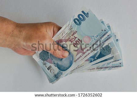 Hand holding Turkish Lira Banknotes. One Hundred Turkish Lira Banknotes with hand. Isolated on white background.