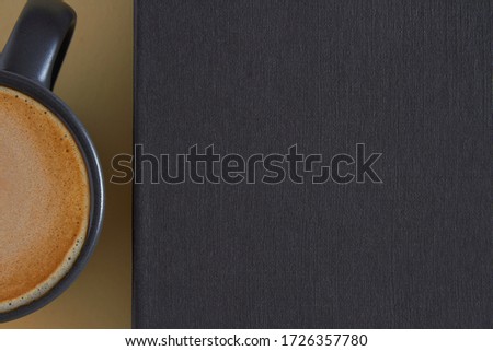 on a yellow pastel paper background, a dark gray coffee mug close with foam, and a graphite - colored book, textured, morning, background, free space