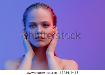 A beautiful young girl in wireless headphones listens to song with a good mood. bright colorful music poster. Royalty-Free Stock Photo #1726419415
