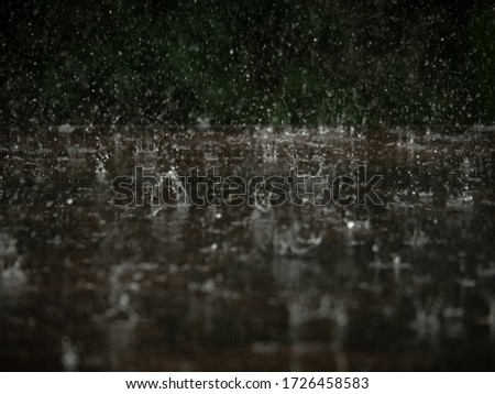 Raindrops falling on wooden floor and splash.