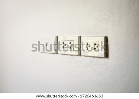 Electricity outlet on the wall that's covered with safety plugs