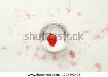 A picture of a strawberry in a glass.