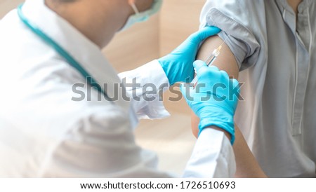 World immunization week and International HPV awareness day concept. Teenager woman having vaccination for influenza or flu shot or HPV prevention vaccine with syringe by nurse or medical officer.  Royalty-Free Stock Photo #1726510693
