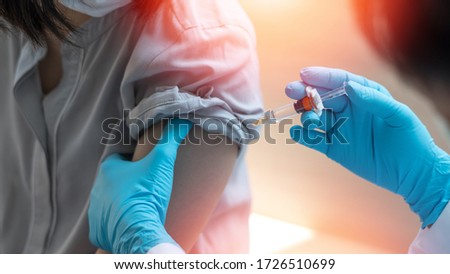 World immunization week and International HPV awareness day concept. Teenager woman having vaccination for influenza or flu shot or HPV prevention vaccine with syringe by nurse or medical officer. 